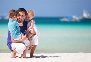 Happy father with his two kids on tropical beach vacation