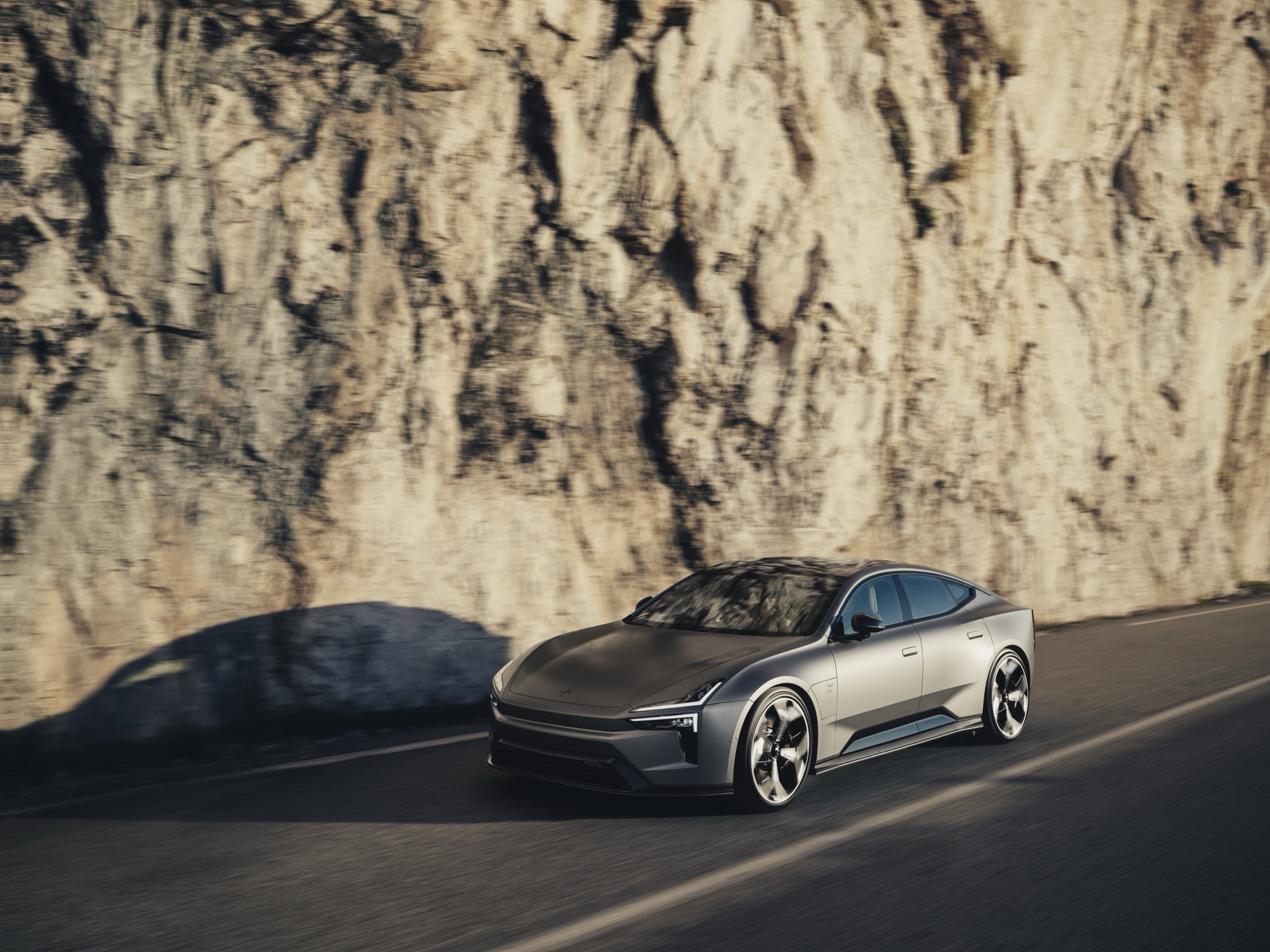 Polestar 5 driving along a road with a cliff behind
