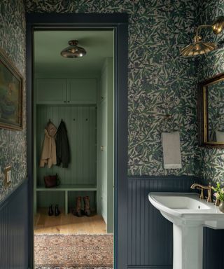 small powder room with traditional heritage wallpaper leading into a boot room