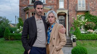 Elisa and Fred looking worried outside their house