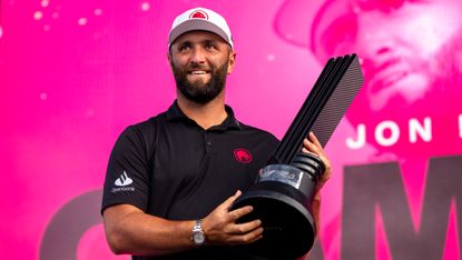 Jon Rahm holding a LIV Golf trophy