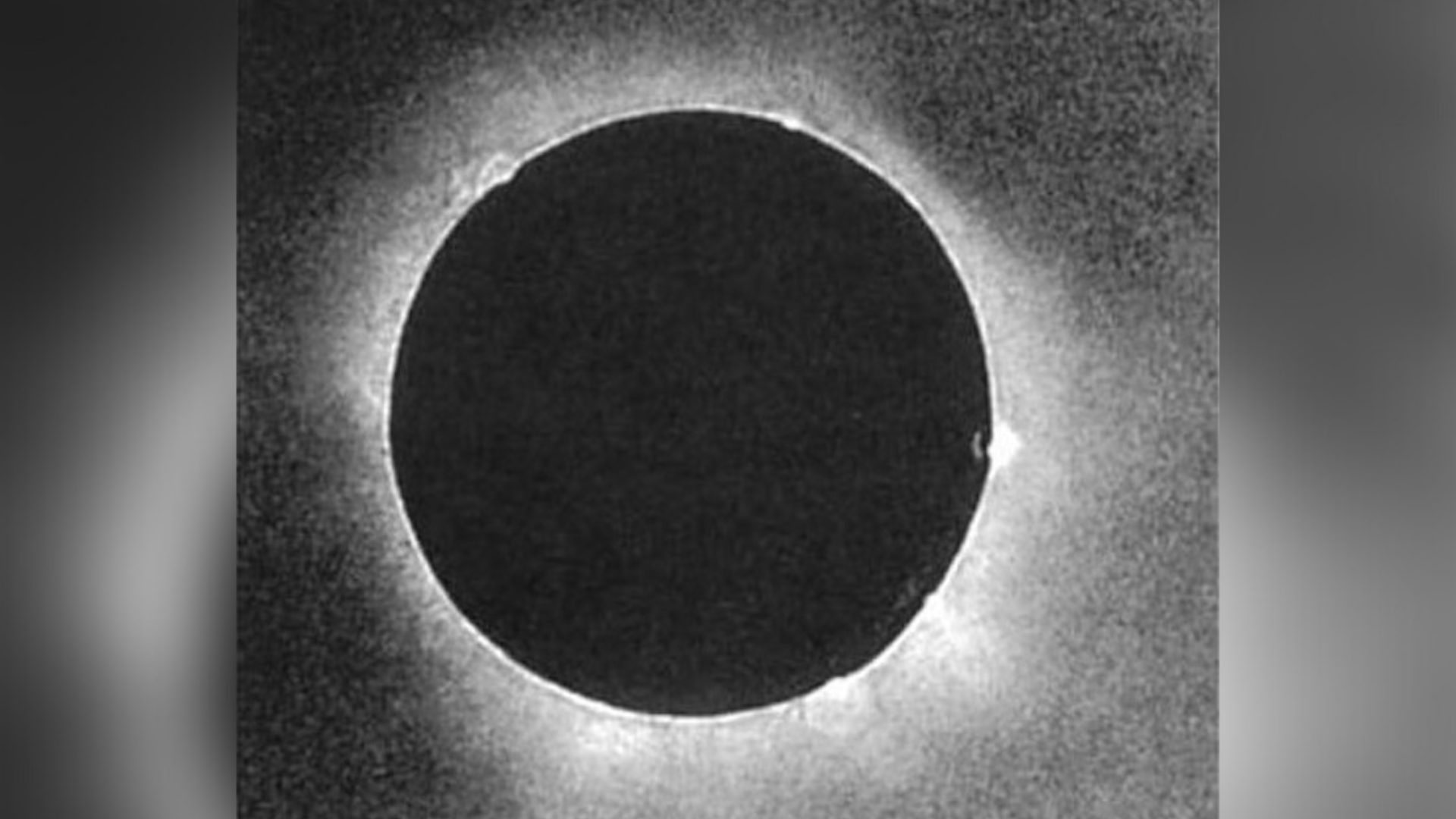 A large black circle in the center of the image is the moon covering the sun in the black and white photo