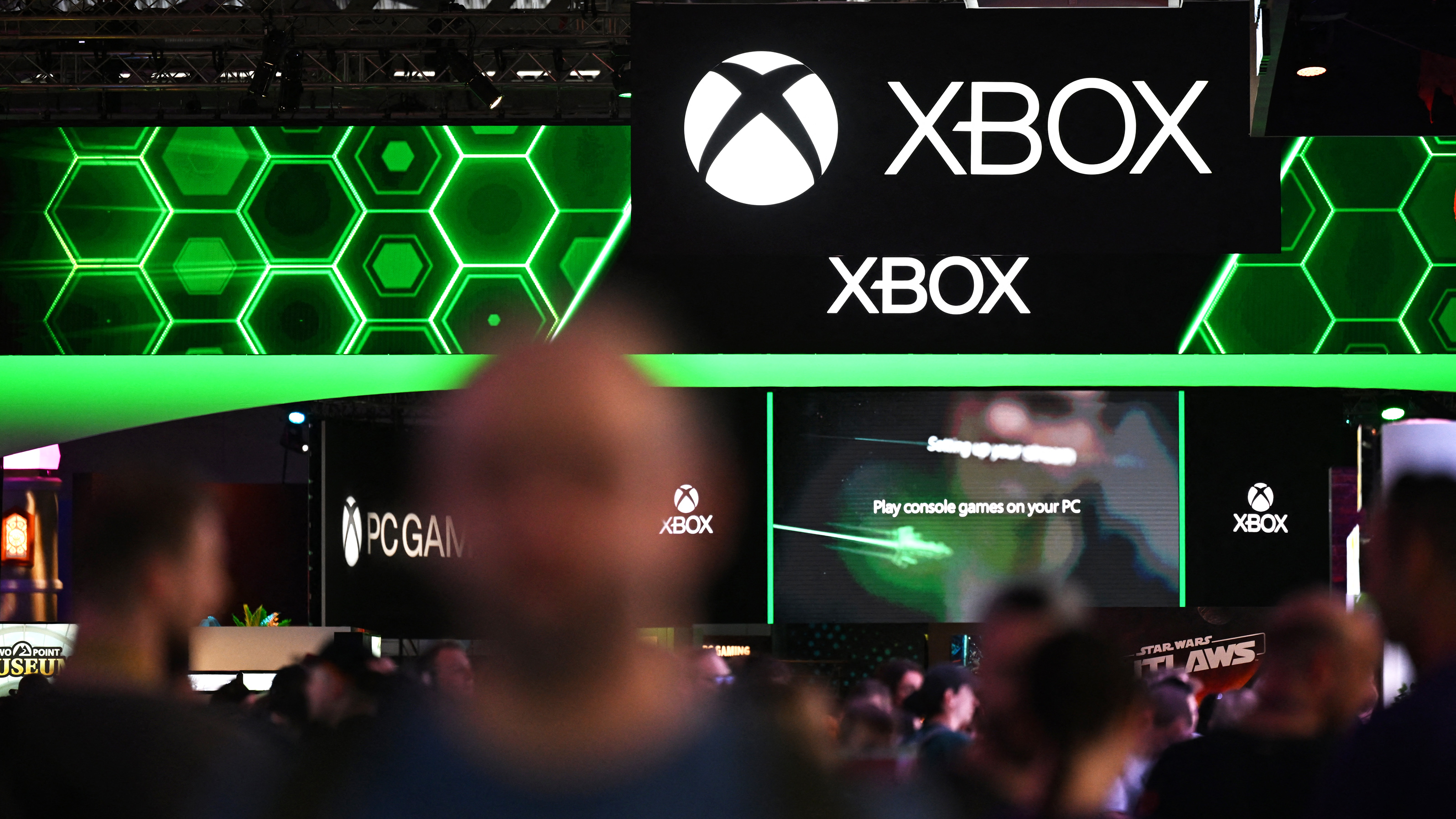 Visitors walk past the Xbox booth at the Gamescom video games trade fair in Cologne, western Germany on August 22, 2024. According to organisers, around 1400 exhibitors from 64 countries will be presenting their products during the fair running until August 25, 2024. (Photo by Ina FASSBENDER / AFP) (Photo by INA FASSBENDER/AFP via Getty Images)          