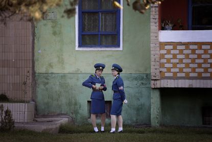 North Korean traffic police women chat next to a residential building while off duty in Pyongyang, North Korea.