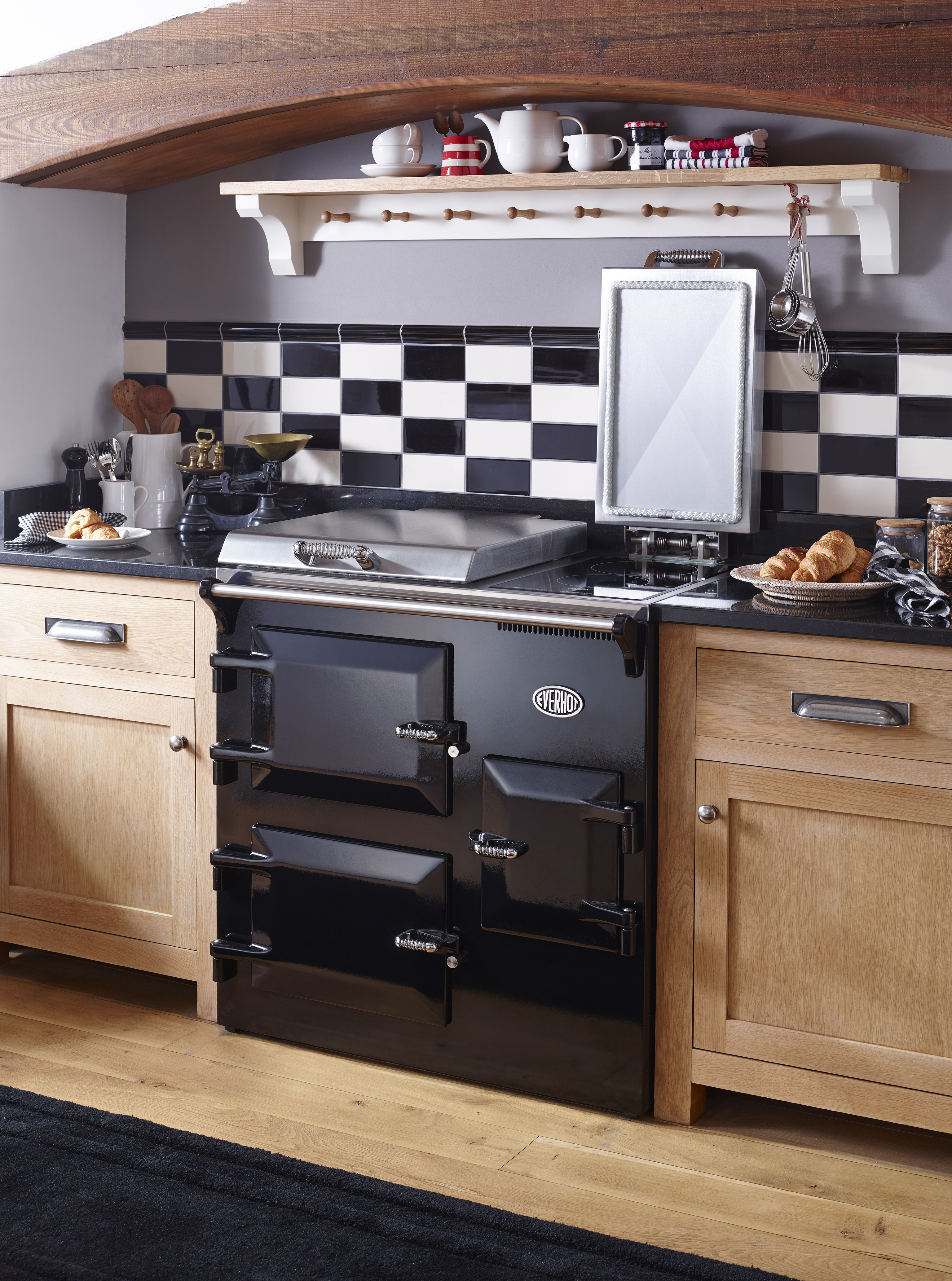 A kitchen with black and white backsplash, and a black oven 