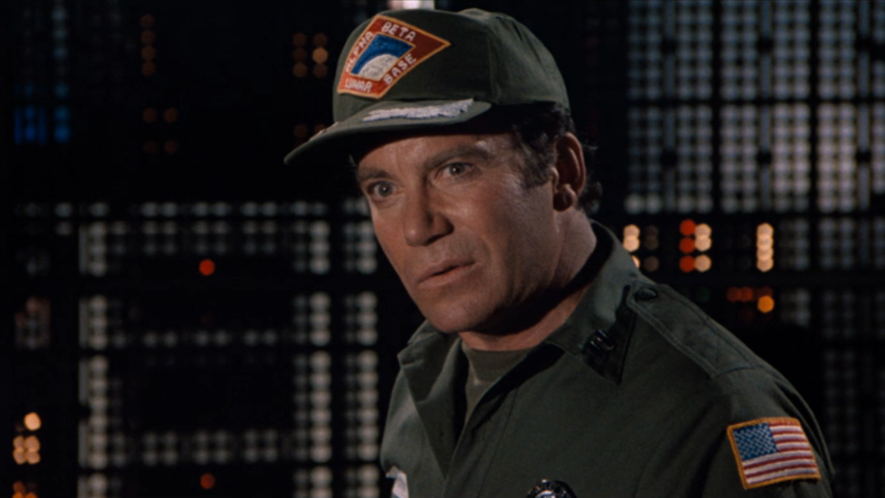 William Shatner se encuentra en una sala de control con una expresión salvaje en Airplane II: The Sequel.