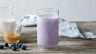Almond and Blueberry Smoothie on a table surrounded by its ingredients