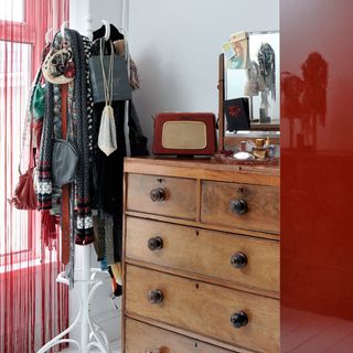 chest on drawers with cloths on hook and radio