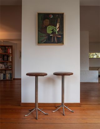 Two stools, wood floor and white wall