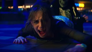 A young teen screaming while trying to crawl away from a killer during the Netflix horror movie, Fear Street.