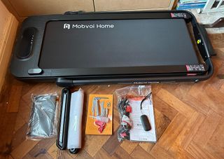 Mobvoi Home treadmill led flat on floor with assembly equipment next to it