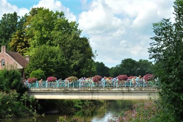 The peloton crosses a bridge