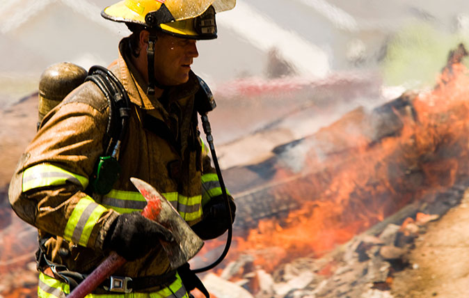 A firefighter surveys the scene after a fire