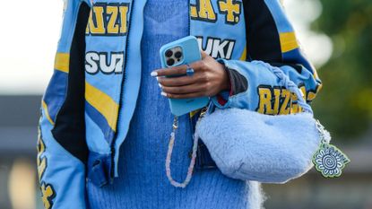 Close up of street style image showing woman with square nails holding her phone