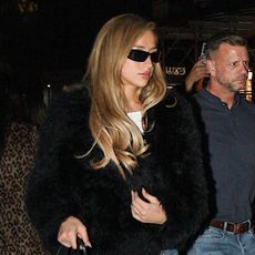 tate mcrae wears a black fur coat, cropped straight jeans, mules, and a black bag.