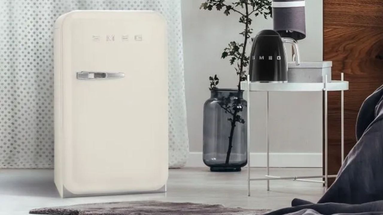 One of the best mini fridges on the market, the Smeg FAB5 Mini Fridge in cream in abedroom