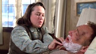 Kathy Bates as Annie Wilkes shaving James Caan while he is lying in bed in the '90s movie Misery