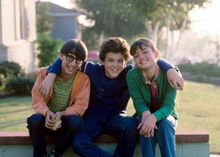 two boys and a girl sit together with their arms around each other in a still for The Wonder Years