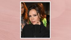 Image of Victoria Beckham smiling with brunette up-do and wearing a black blazer, on a pink background