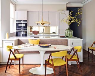 Kitchen with yellow chairs and round table with wooden floor