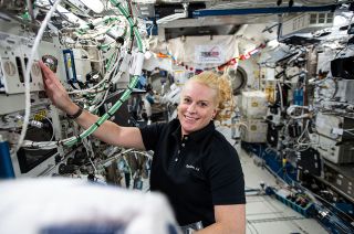 Expedition 64 flight engineer and NASA astronaut Kate Rubins on board the International Space Station with the ISS 20 Years logo in the background. Rubins was aboard the orbiting laboratory to mark the 20th anniversary of crewed operations, Nov. 2, 2020.