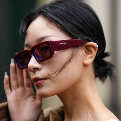 a model wears a pair of prada sunglasses during fashion week