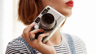 Woman holding camera while wearing Oura smart ring