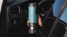 An example of the product affected by the BlendJet 2 blenders recall, a BlendJet 2 portable blender making a blue smoothie in a car