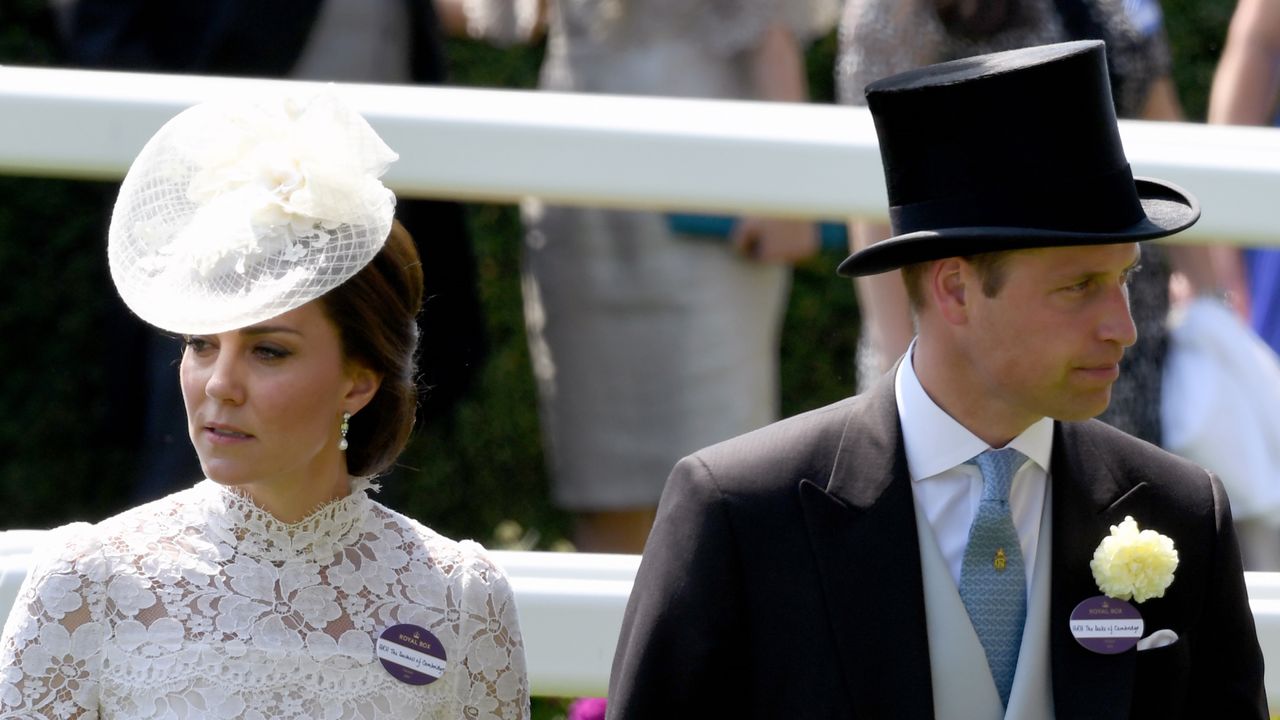 Kate Middleton wears a white lace dress with a matching hat and Prince William wears a top hat and tails