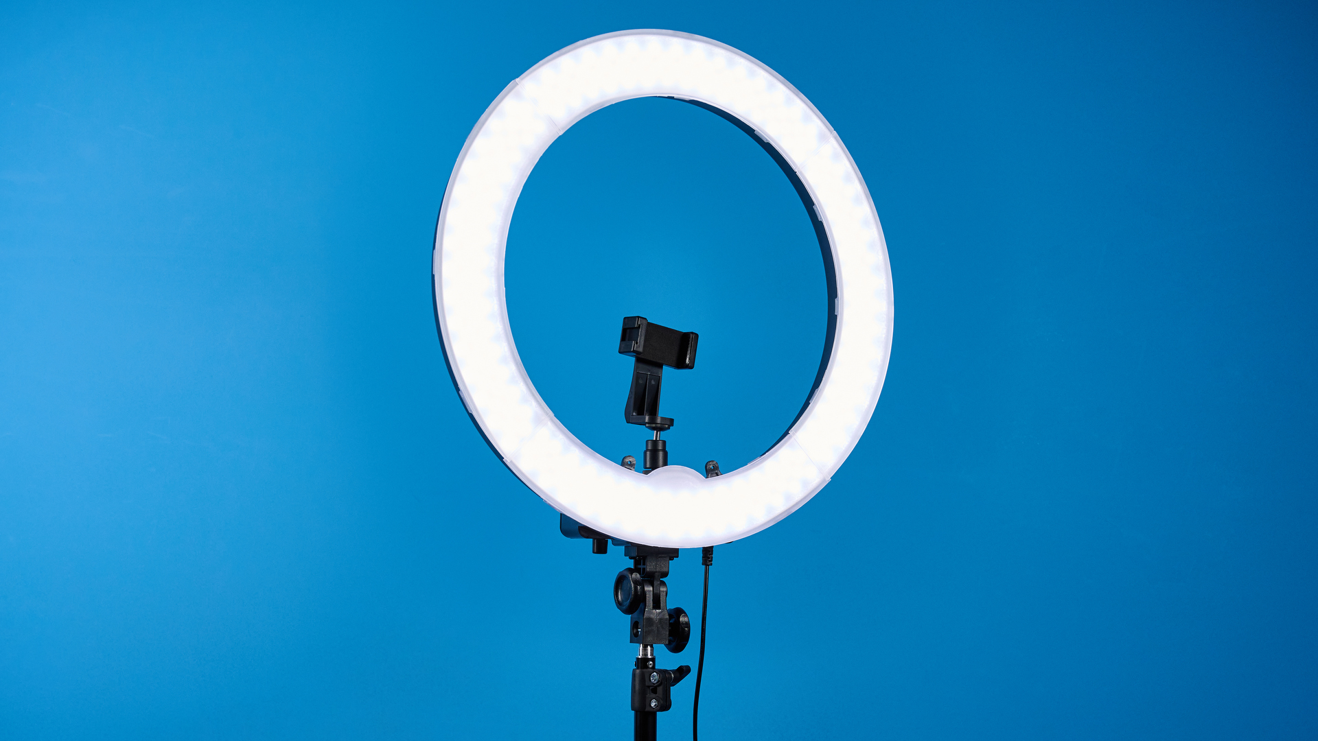 Neewer RL-18 ring light photographed in front of a blue background.