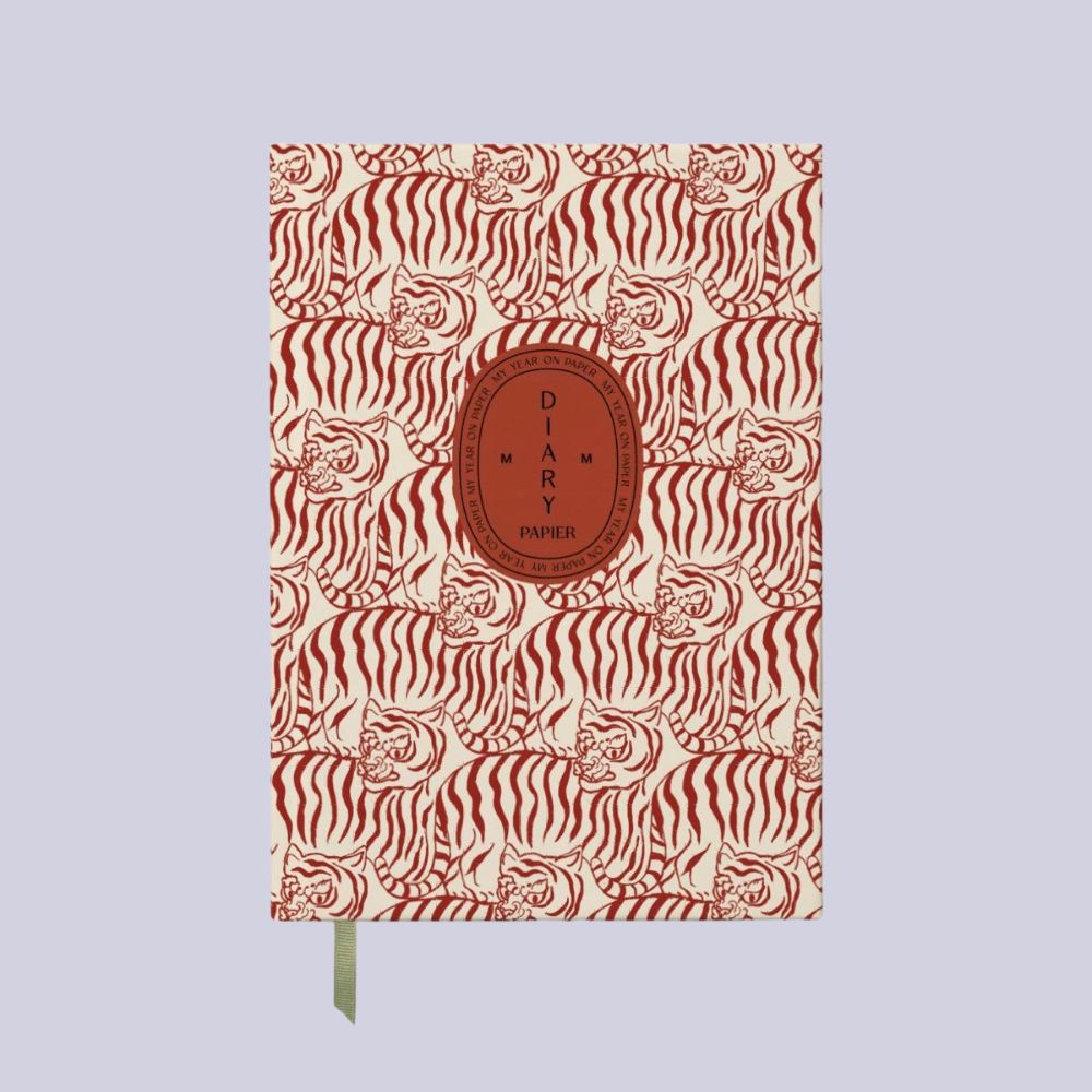 A leopard-pattern yearly planner with a central logo in terracotta read reading "DIARY 2026 Papier", placed against a pale lilac background.