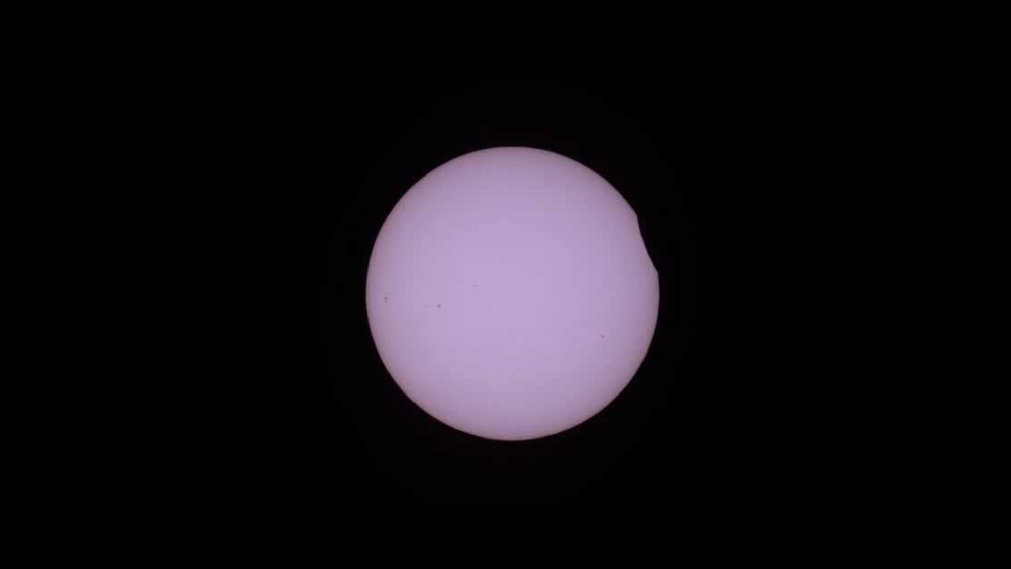 a white orb on a black background with a small section blacked out along its right edge