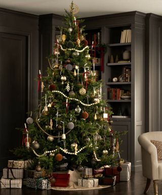 traditional style christmas tree decorated with flocked velvet baubles and wooden bead garlands