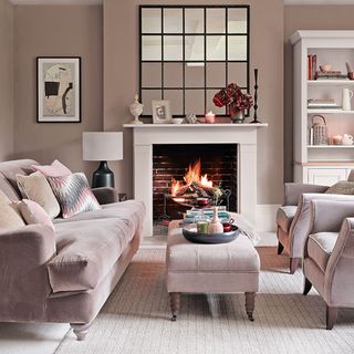 neutral living room with stone fireplace pink sofa and black mantel mirror