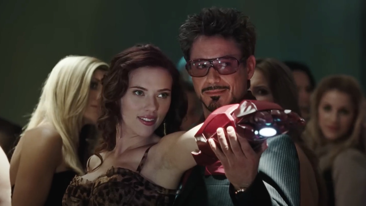 Tony Stark gripping onto Natasha Romanoff&#039;s arm as she uses an Iron Man gauntlet