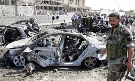 Residents and security personnel gather at the site of an explosion in Damascus on May 10