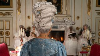 Queen Charlotte faces away from the screen looking at a fireplace in Bridgerton