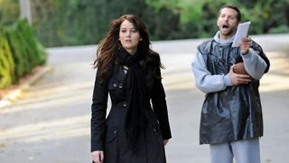 Jennifer Lawrence and Bradley Cooper starring as Patrizio "Pat" Solitano Jr. and Tiffany Maxwell in Silver Linings Playbook, their characters are stood on a road together.