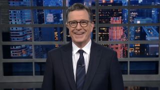Stephen Colbert smiling into the camera during The Late Show monologue