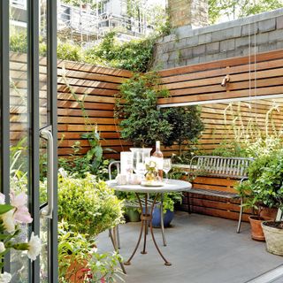 courtyard garden with wood panelled walls and large garden mirror