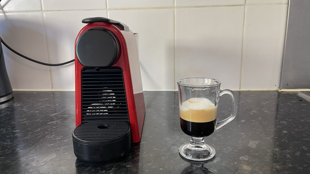 Espresso macchiato coffee next to Nespresso Essenza Mini