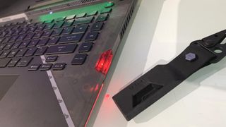 Asus ROG Strix Scar 15 is photographed with its security key gadget