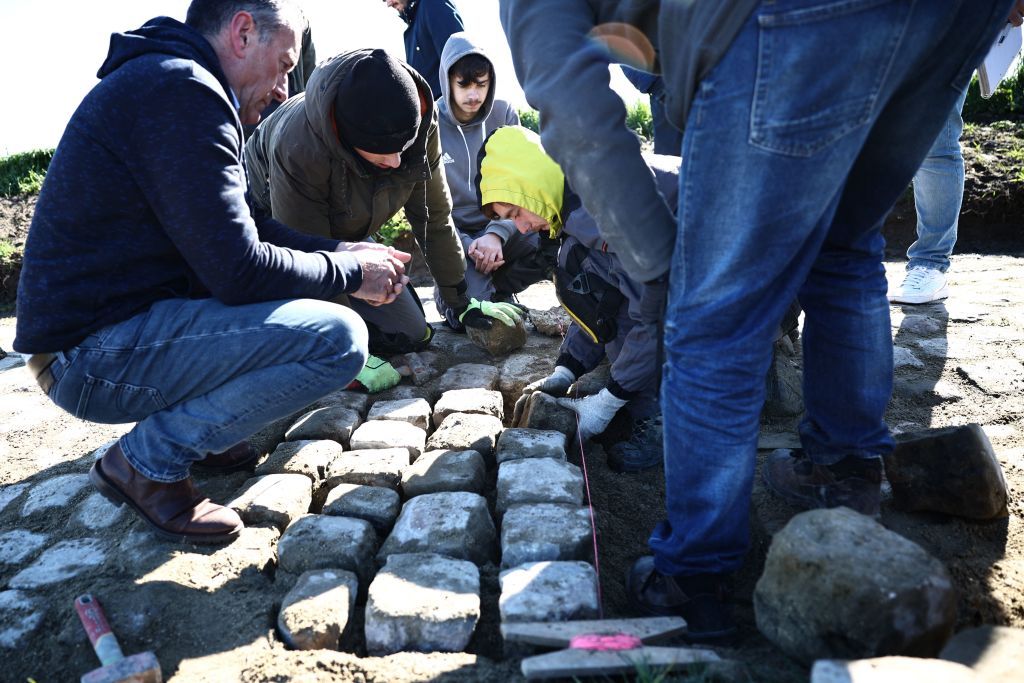 Workers repair cobblestones on the route of the ParisRoubaix cycling race in presence of race director Thierry Gouvenou L near Arenberg on April 4 2023 ahead of this weekends men and women races Photo by AnneChristine POUJOULAT AFP Photo by ANNECHRISTINE POUJOULATAFP via Getty Images
