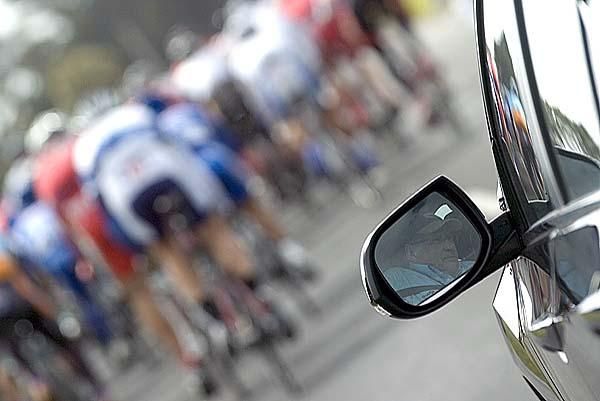 Chief Commissaire Graham Sycamore from New Zealand keeps an eye on the peloton during stage three.