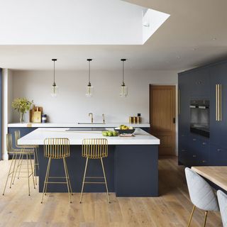 white kitchen with deep blue cabinets and wooden floor