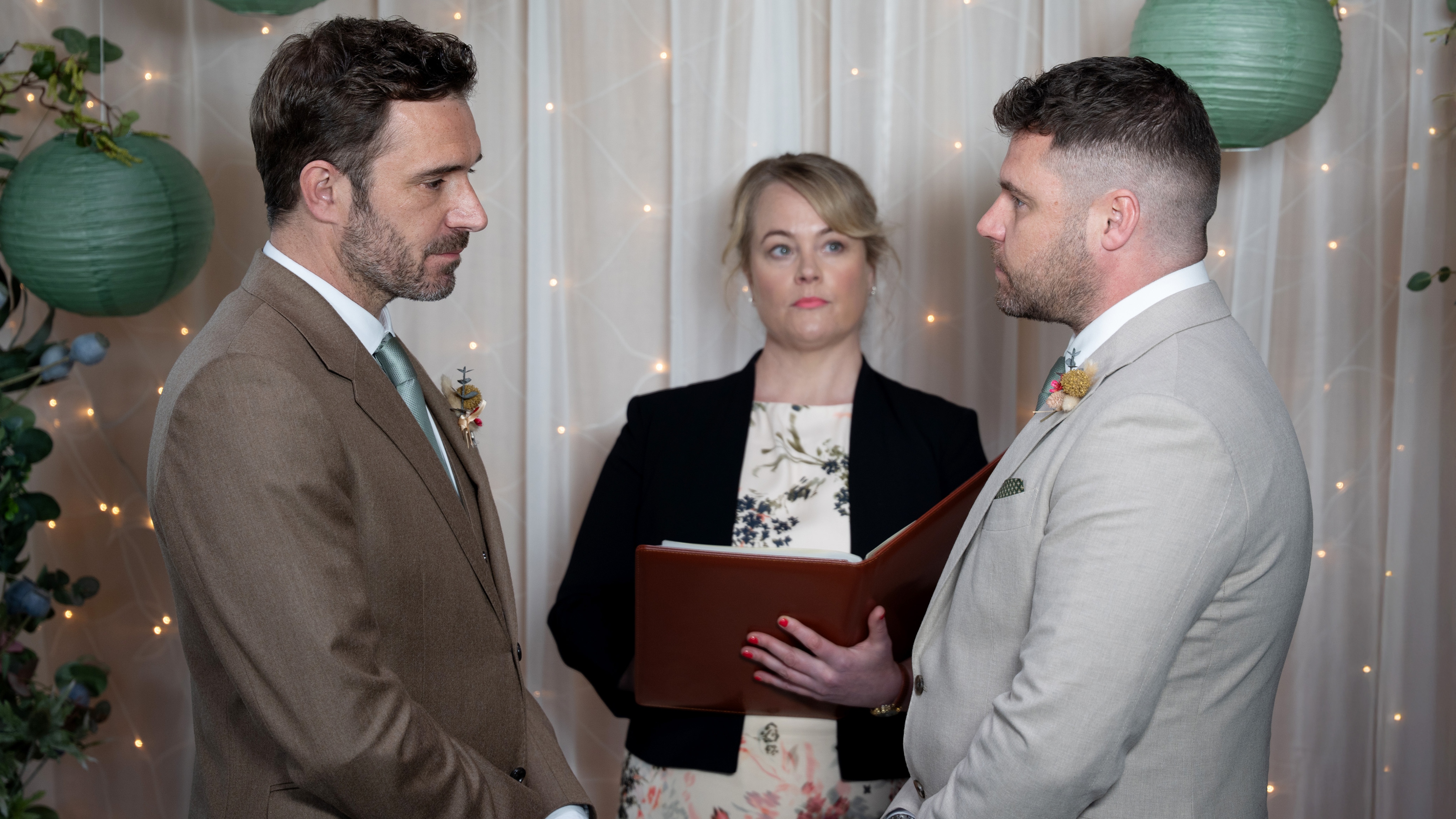 John and Aaron standing at the altar in wedding suits, ready to get married 