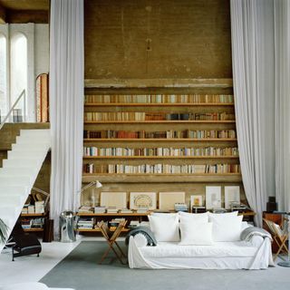 living room with wooden bookshelves and white sofaset