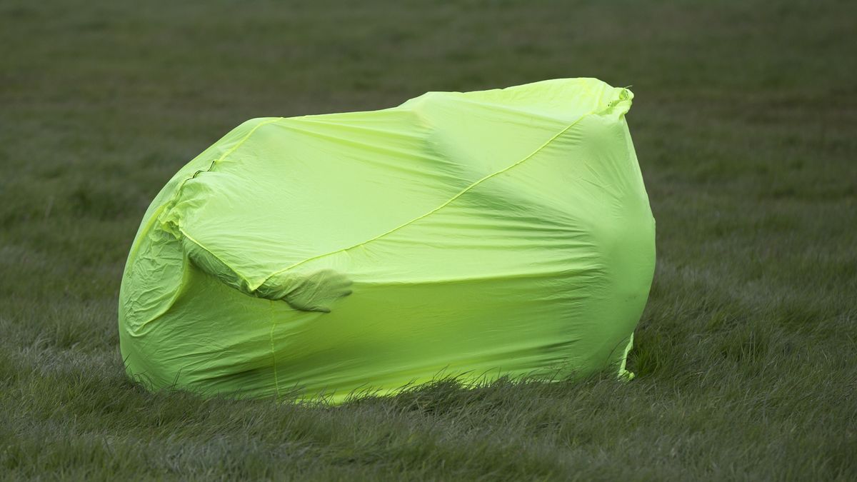 A green bothy bag in a field with people inside it