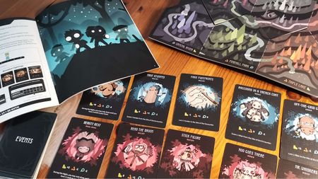 Twisted Cryptids cards, board, and instructions laid out on a wooden surface