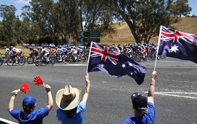 Fans wave the Australian flag as the peloton flies by on the way to Hahndorf